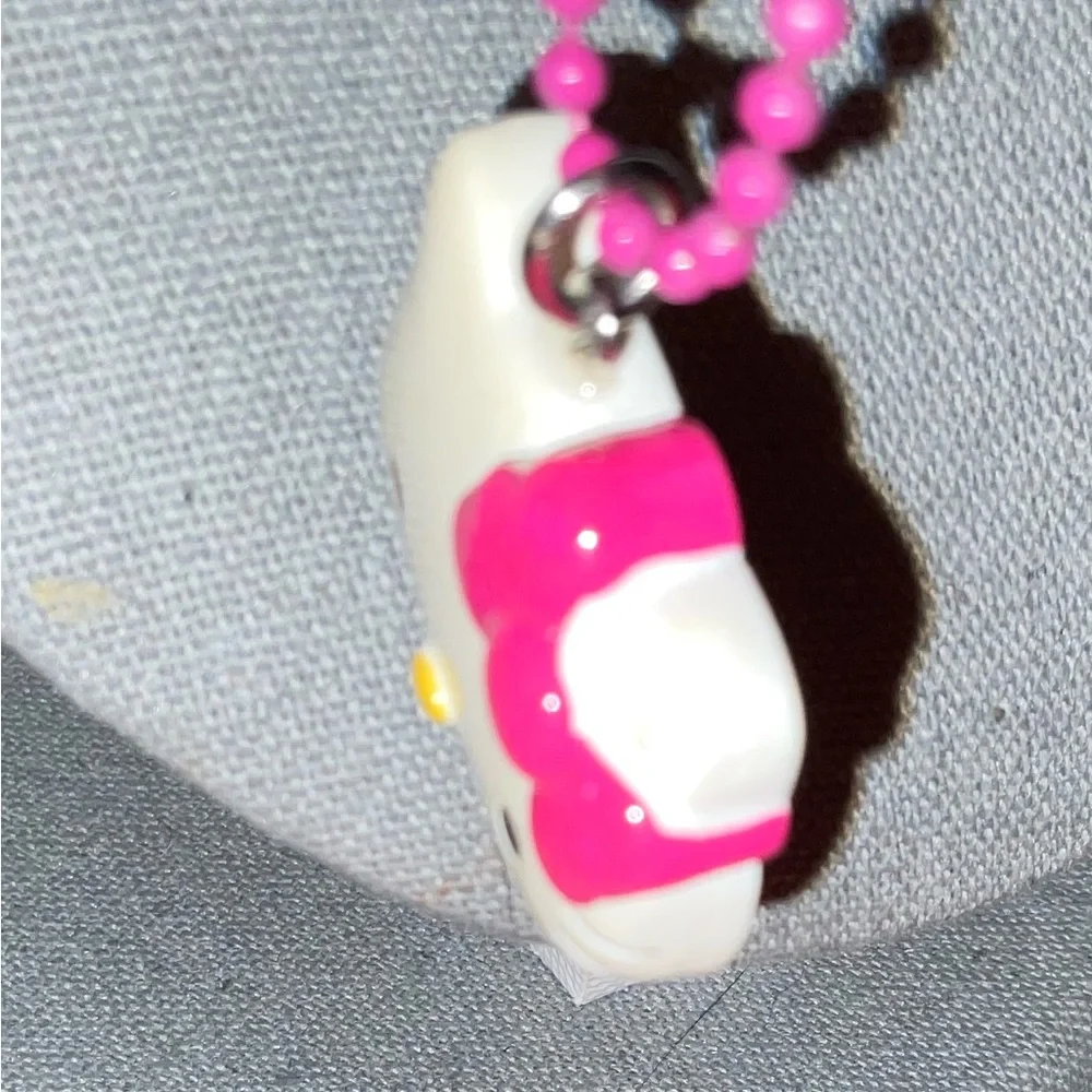Hello Kitty :Kitty face slightly angled on a bight pink beaded necklace blue bow